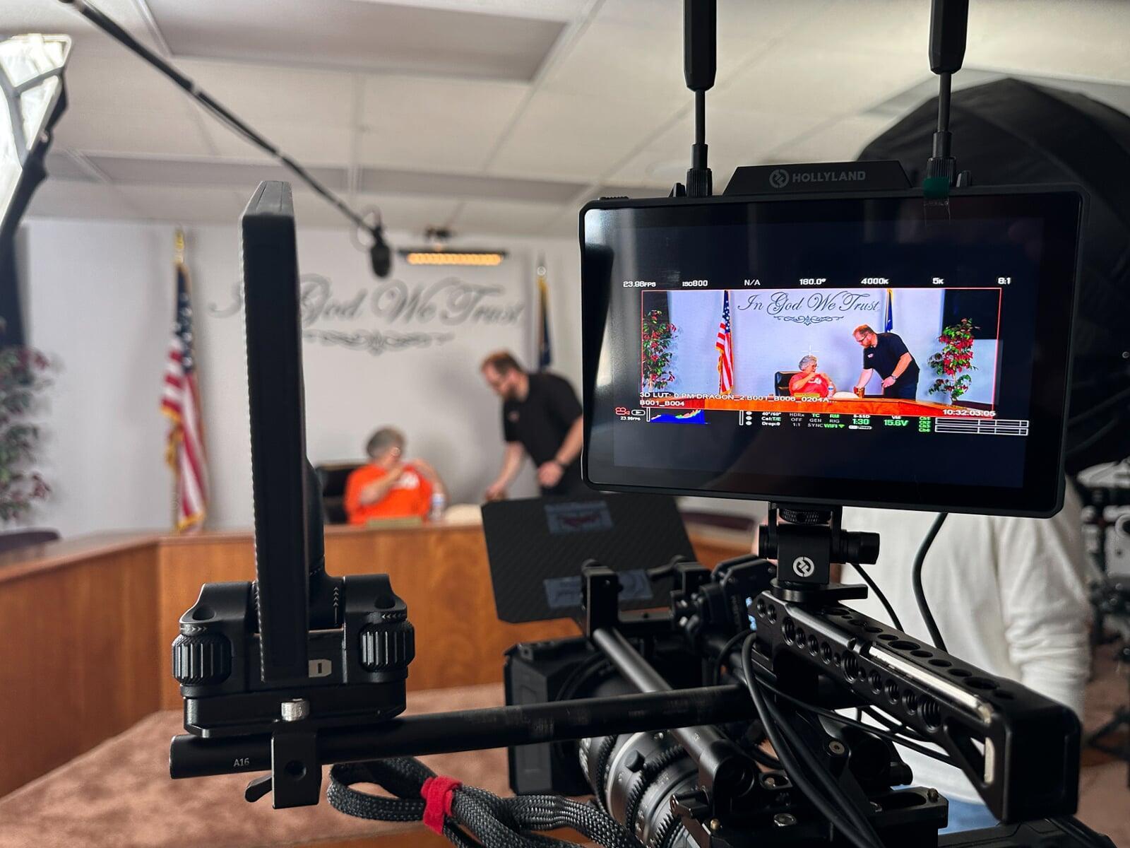 Timothy Bubel prepares a lavaliere mic for an on-camera guest to talk about a local sports hero.